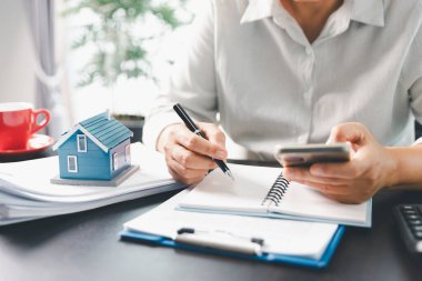 Emlakçı, müşteri temsilciliğine ev almayı kabul etti. Ev modeli, emlakçı, ev, sigorta, kredi emlak geçmişi için kontrat imzalamak isteyen müşteri. Kavram anlaşması.