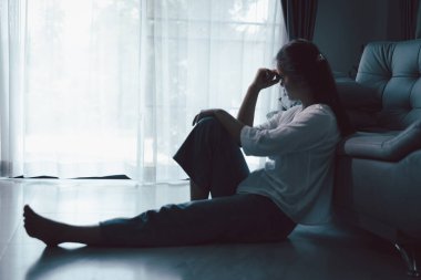 Evdeki kanepede oturan umutsuz, yorgun kız. Genç kadın oturma odasında oturuyor, üzgün ve depresif hissediyor. Psikolojik bir sorun. Depresyon ve yalnızlık kavramı.