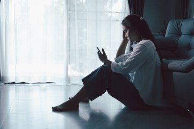 Evdeki kanepede oturan umutsuz, yorgun kız. Genç kadın oturma odasında oturuyor, üzgün ve depresif hissediyor. Psikolojik bir sorun. Depresyon ve yalnızlık kavramı.