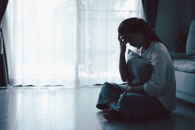 Evdeki kanepede oturan umutsuz, yorgun kız. Genç kadın oturma odasında oturuyor, üzgün ve depresif hissediyor. Psikolojik bir sorun. Depresyon ve yalnızlık kavramı.