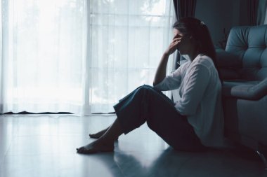 Evdeki kanepede oturan umutsuz, yorgun kız. Genç kadın oturma odasında oturuyor, üzgün ve depresif hissediyor. Psikolojik bir sorun. Depresyon ve yalnızlık kavramı.