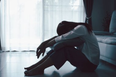 Evdeki kanepede oturan umutsuz, yorgun kız. Genç kadın oturma odasında oturuyor, üzgün ve depresif hissediyor. Psikolojik bir sorun. Depresyon ve yalnızlık kavramı.