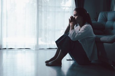 Evdeki kanepede oturan umutsuz, yorgun kız. Genç kadın oturma odasında oturuyor, üzgün ve depresif hissediyor. Psikolojik bir sorun. Depresyon ve yalnızlık kavramı.