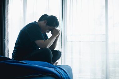 Stresli bir kadın karanlık bir odada tek başına oturuyor, başını eğiyor, depresyonu, endişeyi, umutsuzluğu, yalnızlığı, zihinsel sağlık mücadelesini, tükenmiş ve duygusal acıyı simgeliyor..