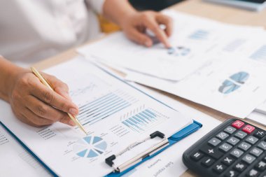Finansal tabloyu ve grafiği masasında kalem ve hesap makinesi, muhasebe yönetimi konsepti, bütçe planlaması, mali rapor ve veri analizi ile analiz eden iş adamlarının kapatılması.