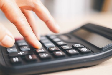 Bütçe hesaplama, muhasebe ve finansal analiz için hesap makinesinin tuşlarına yakın çekim. İş giderleri planlaması, vergi hesaplaması, ofis masası geçmişi, evrak işleri için kopya alanı.