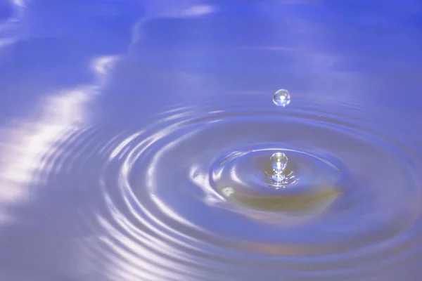 Goccia d'acqua che cade in acqua facendo una goccia perfetta . — Foto Stock