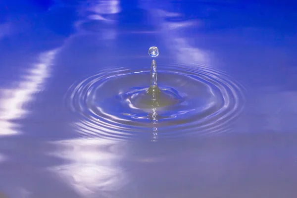 Goccia d'acqua che cade in acqua facendo una goccia perfetta . — Foto Stock