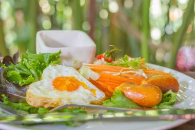 İngiliz kahvaltısı kızarmış yumurta, pastırma, sosis ve taze salata ile