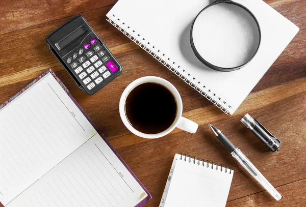 Koffie beker en kantoorbenodigdheden. Bekijk van bovenaf. Close-up op hout — Stockfoto