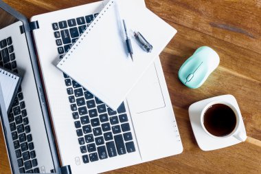 Kahve fincanı: Not defteri ve ahşap masa üstünde laptop. Yukarıdan görüntülemek