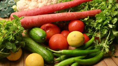 Masadaki organik sebzeler, domatesler, limonlar, havuçlar, maydanozlar, salatalıklar, yeşil biberler.