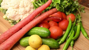 Masadaki organik sebzeler, domatesler, limonlar, havuçlar, maydanozlar, salatalıklar, yeşil biberler.