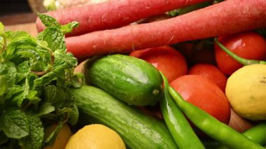 Masadaki organik sebzeler, domatesler, limonlar, havuçlar, maydanozlar, salatalıklar, yeşil biberler.