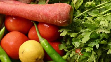 Masadaki organik sebzeler, domatesler, limonlar, havuçlar, maydanozlar, salatalıklar, yeşil biberler.