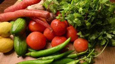 Masadaki organik sebzeler, domatesler, limonlar, havuçlar, maydanozlar, salatalıklar, yeşil biberler.