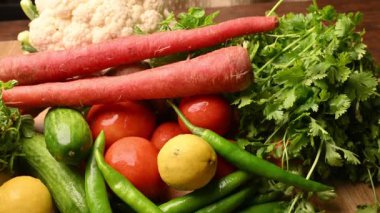 Masadaki organik sebzeler, domatesler, limonlar, havuçlar, maydanozlar, salatalıklar, yeşil biberler.