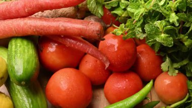 Masadaki organik sebzeler, domatesler, limonlar, havuçlar, maydanozlar, salatalıklar, yeşil biberler.