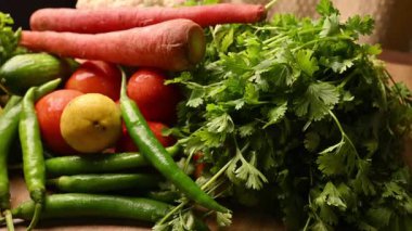 Masadaki organik sebzeler, domatesler, limonlar, havuçlar, maydanozlar, salatalıklar, yeşil biberler.