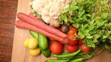 Masadaki organik sebzeler, domatesler, limonlar, havuçlar, maydanozlar, salatalıklar, yeşil biberler.