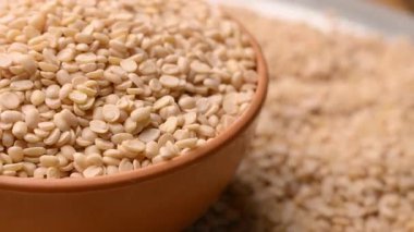 White Split Urad Dal in Bowl Döndürme Üst Görünümü - Raw Split Kurutulmuş Beyaz Urad Dal - Bölünmüş Siyah Gram Mercimek İzole