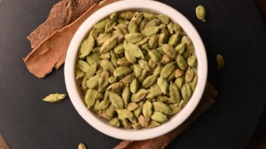 Siyah Arkaplan Dönen Görüntülerinde Tarçın Çubukları (Dalchini) ile Beyaz Bovling 'de Kakule (Elechi) Üst Görünümü