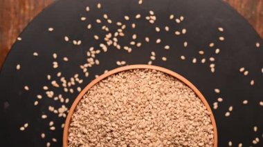 Siyah Arkaplanda Dönen Beyaz Kasedeki Susam Tohumlarının Üst Görünümü Görüntüsü