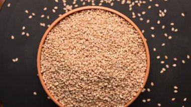 Siyah Arkaplanda Dönen Beyaz Kasedeki Susam Tohumlarının Üst Görünümü Görüntüsü