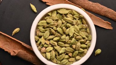 Siyah Arkaplan Dönen Görüntülerinde Tarçın Çubukları (Dalchini) ile Beyaz Bovling 'de Kakule (Elechi) Üst Görünümü