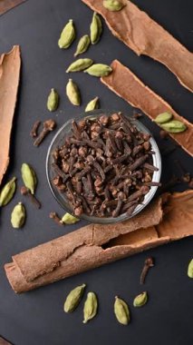 Siyah Arkaplanda Tarçın Çubukları (Dalchini) ve Kakule (Elechi) ile Beyaz Bovling 'de En İyi Karanfiller (Laung)