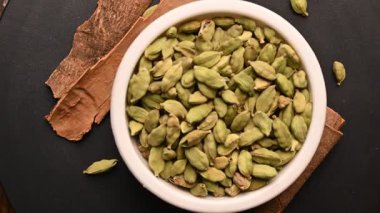 Siyah Arkaplan Dönen Görüntülerinde Tarçın Çubukları (Dalchini) ile Beyaz Bovling 'de Kakule (Elechi) Üst Görünümü