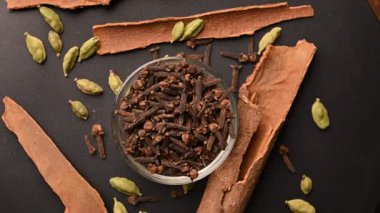 Siyah Arkaplanda Tarçın Çubukları (Dalchini) ve Kakule (Elechi) ile Beyaz Bovling 'de En İyi Karanfiller (Laung)