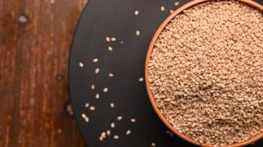 Siyah Arkaplanda Dönen Beyaz Kasedeki Susam Tohumlarının Üst Görünümü Görüntüsü