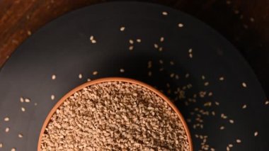 Siyah Arkaplanda Dönen Beyaz Kasedeki Susam Tohumlarının Üst Görünümü Görüntüsü