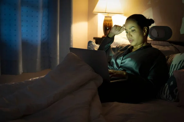 Focus on laptop. woman people in robe using smart cellphone.Sad Depressed Insomnia girl.Protection and Treatment of Major Depressive Disorder Problem Concept. Technology gadget and phone addiction.