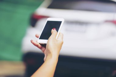 Smartphone kullanarak araba kilidini açıyorum. Araba motoru için yeni teknoloji. Kapıyı açmak ya da arabayı çalıştırmak için el ele tutuşan akıllı telefon. Teknoloji, akıllı yaşam konsepti. seçici odak içinde.