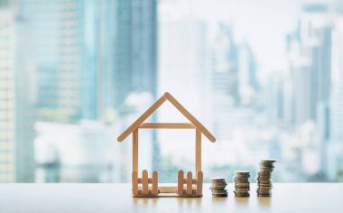 Bozuk para yığını bozuluyor. Mini ahşap ev ve bozuk para yığını düşüyor. İpotek ve gayrimenkul yatırımı veya Sigorta Finans ve Yatırım konsepti.