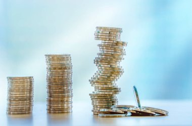 Bozuk para yığını bozuluyor. Mini ahşap ev ve bozuk para yığını düşüyor. İpotek ve gayrimenkul yatırımı veya Sigorta Finans ve Yatırım konsepti.