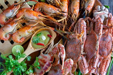 Tayland yaz tatilinde kapanış Tayland deniz ürünleri tabağı. Kepekli yengeç ve karides. Baharatlı yeşil soslu Tayland deniz ürünleriyle servis ediliyor. Lezzetli Okyanus gurmesi yemek geçmişi.