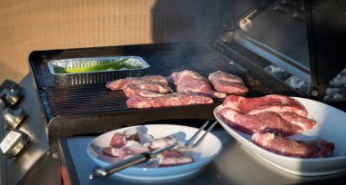 Ağır çekimde yanan kömürlerin içinde baharatlı ve otlu sulu et bifteği, ateş ve duman. Izgara çizgili sulu biftek piknik kutlaması için hazır. Barbekü ızgarası