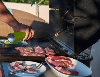 Ağır çekimde yanan kömürlerin içinde baharatlı ve otlu sulu et bifteği, ateş ve duman. Izgara çizgili sulu biftek piknik kutlaması için hazır. Barbekü ızgarası