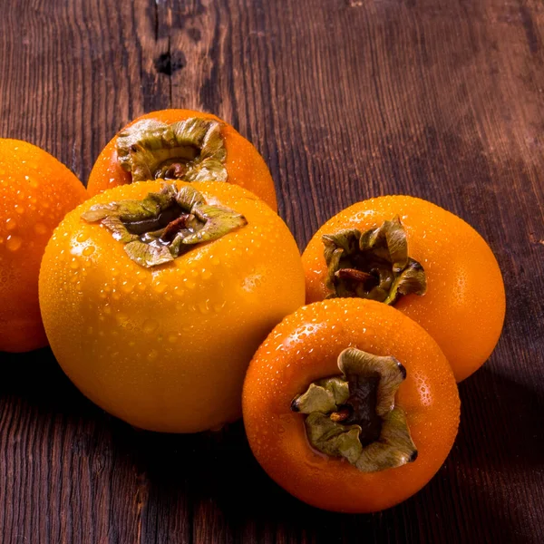 Persimmon Auf Einem Hölzernen Hintergrund Mit Wassertropfen Seitenansicht Nahaufnahme Kopierraum — Stockfoto