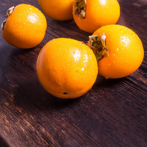 Persimmon Auf Einem Hölzernen Hintergrund Mit Wassertropfen Seitenansicht Nahaufnahme Kopierraum — Stockfoto