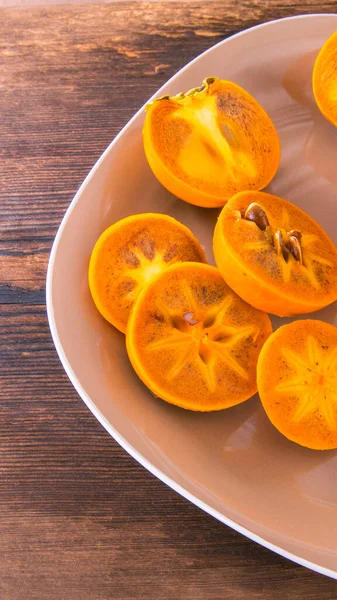 Persimmon Cut Slices Halves Persimmon Plate Wooden Table Close Copy — Stock Photo, Image