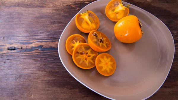 Persimmon Scheiben Geschnitten Und Hälften Von Kaki Auf Einem Teller — Stockfoto