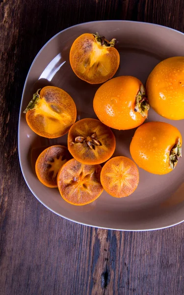 Persimmon Sliced Half Water Drops Plate Wooden Table Top View — Stock Photo, Image