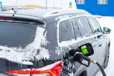 Kışın arabaya yakıt ikmali yapılıyor.,