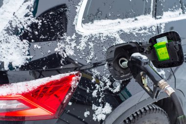 Kışın arabaya yakıt ikmali yapılıyor.,