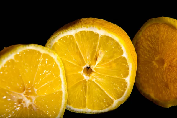 Zitronenhälften Und Zitronenscheibe Auf Schwarzem Hintergrund Nahaufnahme Tapete Postkarte Makrofotografie — Stockfoto