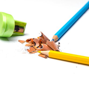 Renkli kalemler ve metal açacağı, beyaz arkaplanda izole edilmiş renkli kalem dosyaları, yakın plan, metin için boşluk